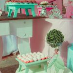 A delightful pink and teal princess-themed party setup with sweets and decorations.