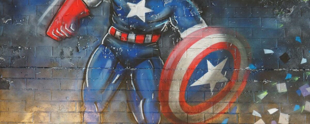 man in blue and red suit holding red and blue shield